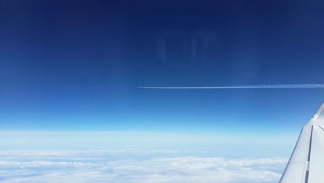 Flugzeug-Fliegt-über-Wolken-Mit-Spur-Aus-Dem-Fenster-Mit-Flügel-Und-Horizont