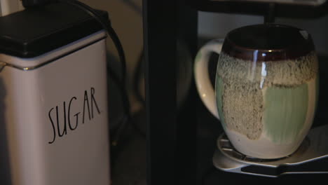 Aus-Einer-Angeschlagenen-Dekorativen-Kaffeetasse-Tritt-Dampf-Aus,-Während-Kaffee-Aus-Einer-Kaffeemaschine-Zu-Hause-Tropft