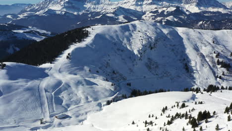 Luftaufnahme,-Die-Nach-Oben-Schwenkt,-Um-Das-Skigebiet-Praz-Sur-Arly-Und-Eine-Bergskyline-In-Den-Französischen-Alpen-Im-Winter-Bei-Sonnenschein-Zu-Zeigen