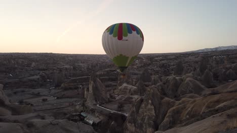 Colourful-hot-air-balloons-fly-over-Goreme-town-in-Cappadocia,-Turkey