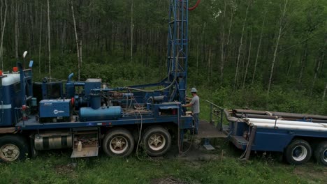 Overhead-panning-aerial-view-of-water-well-drilling-rig-and-operator