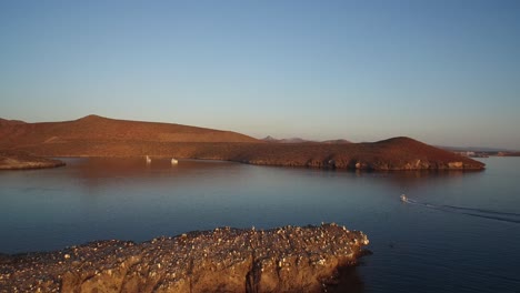 Luftaufnahme-Eines-Bootes,-Das-Bei-Sonnenuntergang-In-Einer-Ruhigen-Bucht-Ankommt,-Meer-Von-Cortez,-Baja-California-Sur