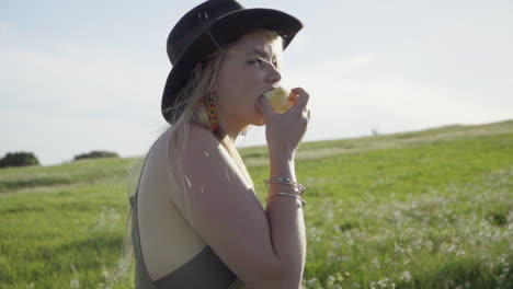 SLOMO-of-Young-Woman-Eating-an-Apple-in-a-Field-of-Flowers