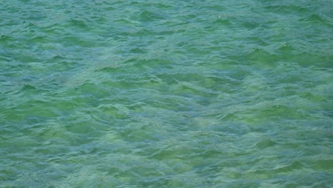 Turquoise-coloured-water-swirling-around,-shallow-with-amazing-texture