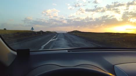 Slow-Motion:View-from-inside-car-on-empty-hilly-road-leading-to-horizon-line-at-sunset-or-sunrise