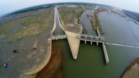 Aerial-view-of-spillway-of-a-dam,-A-van-and-some-visitors-are-there