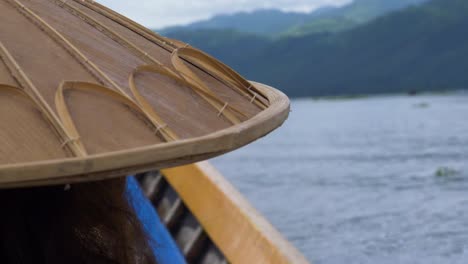 Traditional-Myanmar-bamboo-hat-on-person-boating-across-Inle-Lake