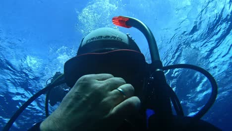 Scuba-diver-checking-his-mask-after-entering-the-sea