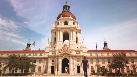 Man-walking-towards-Pasadena-City-Hall-Building,-Low-Angle-Shot,-in-Mediterranean-and-Spanish-Revival-Style,-California