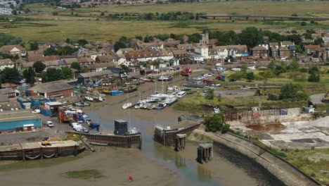 Pullback-aerial-establishing-shot-from-the-lock-at-Queenborough-on-the-Isle-Of-Sheppey,-Kent,-UK-to-reveal-Sheerness-Town---Port