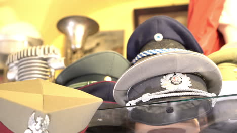 Panoramic-of-world-war-military-hats-and-helmets-in-antique-shop-in-Warsaw-old-town-4k