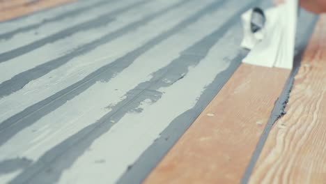 Close-up-hands-removing-masking-tape-from-boat-roof-douglas-fir-planking
