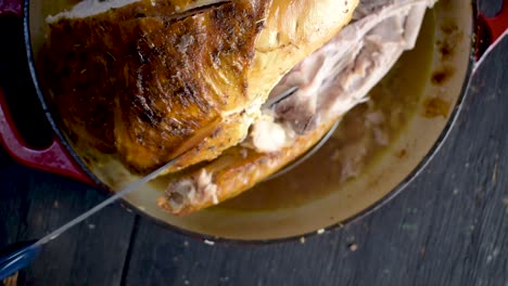 carving-baked-whole-turkey-with-herbs-with-electric-knife-top-view