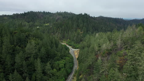 Aerial-drone-flyover-of-the-intersection-of-two-country-highways-surrounded-by-dense-forests-in-Northern-California