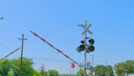 Bahnübergang-Mit-Blinkenden-Roten-Lichtern-Und-Fallenden-Schranken