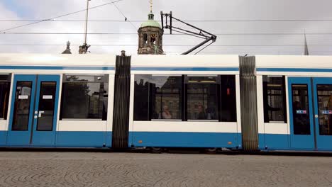 Tram-passing-by-at-Dam-Square,-Amsterdam,-Netherlands