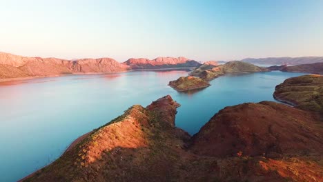 Aerial-tracking-shot-of-spectacular-lake-and-arid-mountains-at-dusk