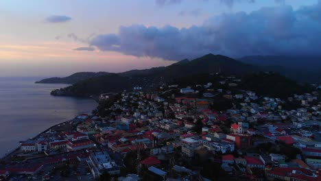 Epic-aerial-of-the-sun-setting-over-the-Bell-Tower-in-St-George,-Grenada