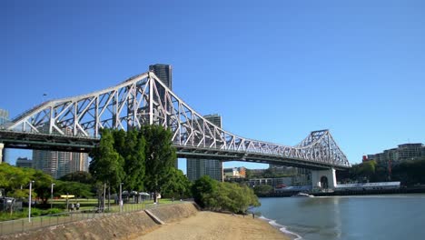 Vista-Icónica-Del-Puente-De-La-Historia-De-Brisbane,-Mirando-Río-Arriba-Hacia-La-Ciudad-Mientras-Los-Famosos-Transbordadores-Citycat-Navegan-Por-El-Río-Brisbane