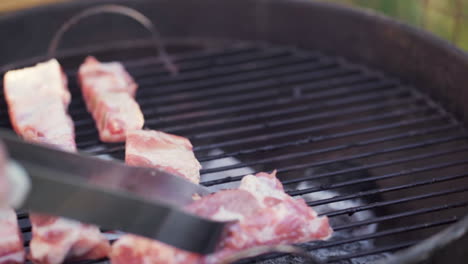 Slow-Motion-of-Tongs-Laying-Meat-on-Smokey-BBQ-Grill