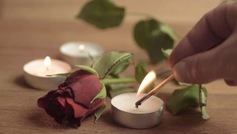 Lighting-a-tea-light-candle-with-red-rose-for-romantic-evening
