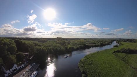 Aerial-Drone-Footage-of-a-boat-sailing-along-the-River-Yare,-Norfolk
