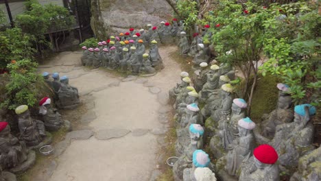 Kleine-Buddha-Statuen-Mit-Wollmütze-Auf-Einem-Pfad-Der-Buddhistischen-Tempelanlage-Daisho-in-Auf-Der-Insel-Miyajima,-Präfektur-Hiroshima