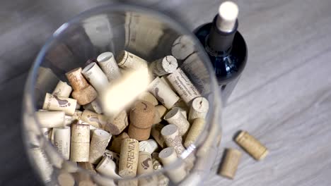 SLOMO:-A-pile-of-corks-and-wine-bottle-in-a-glass-container