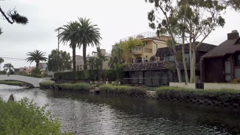 slow-motion-forward-shot-of-Venice-Canals,-showing-canal-front-houses-on-an-overcast-day,-Los-Angeles