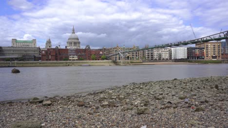 View-of-Londons-iconic-St-Pauls-cathedral-and-busy-Millennium-bridge-swarming-with-tourists-across-the-thames