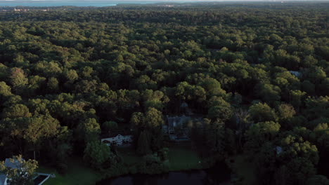 Drone-flight-above-a-wealthy-Greenwich,-Connecticut-neighborhood,-with-a-shot-of-a-glass-smooth-pond