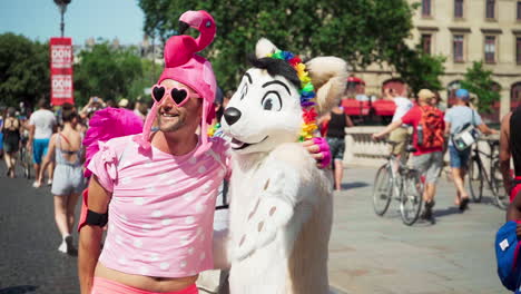 Man-dressed-in-pink-with-flamingo-hat-poses-with-another-person-dressed-in-a-furry-costume-at-the-Pride-Parade-2019-in-Paris,-France