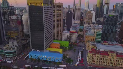 Fast-moving-aerial-timelapse-hyperlapse-of-a-modern-city-with-tall-building-under-construction-and-busy-highway-at-sunset