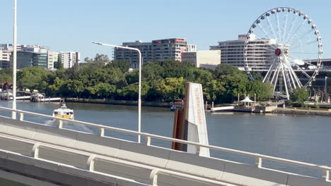 Die-Brisbane-City-Cat-Ferry-Verlässt-Den-North-Quay-Terminal-In-Richtung-South-Bank-Mit-Dem-Rad-Von-Brisbane-Im-Hintergrund