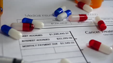 Expensive-prescription-drug-pills-and-medicine-spilling-in-slow-motion-on-a-prop-health-insurance-form