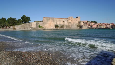 Slow-panning-shot-showing-the-historic-town-of-Collioure-and-its-beach-on-a-windy-day