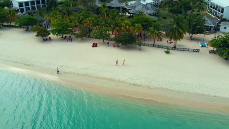 Aerial-view-couple-walking-along-Grand-Anse-Beach-back-to-the-resort-on-the-Caribbean-island-of-Grenada