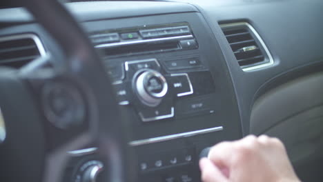 Pressing-buttons-and-turning-the-volume-dial-on-a-car-radio