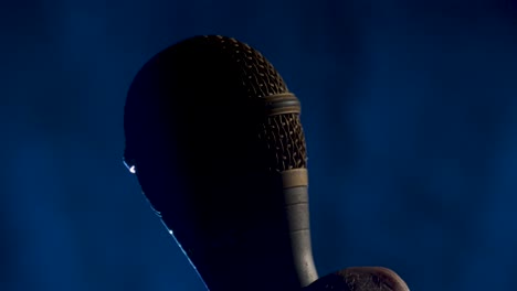 Microphone-rises-into-a-shot-on-a-smokey-background