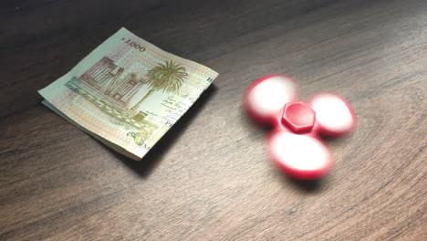 money-and-a-fidget-spinner-on-a-table