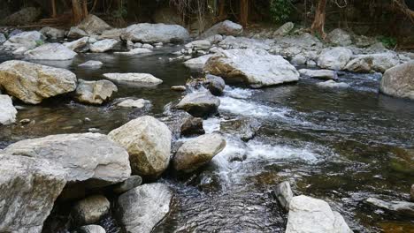 Still-footage-of-water-flowing-through-rocks-in-Freshwater-Creek,-near-Cairns,-Queensland,-Australia