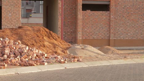 Pan-of-new-house-construction-site-with-bricks-and-sand-work-in-progress