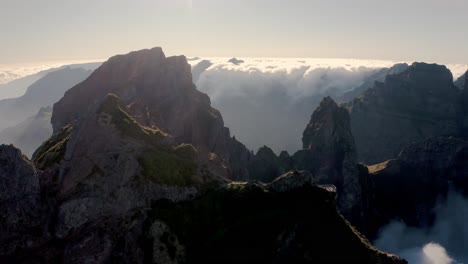 Drone-shot-of-Madeira-with-cliffs,-mountains,-and-cloud-scenery-at-sunset