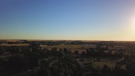 Aerial-Drone-view-going-up-in-little-agricultural-town-during-sunset,-in-Coronel-Dorrego,-Argentina