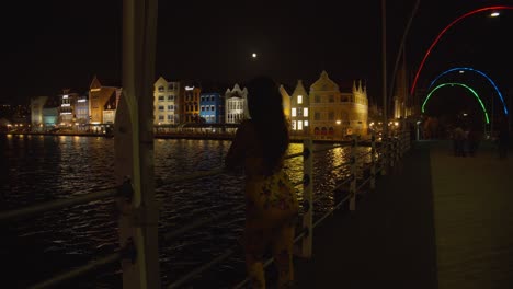 A-sexy-model-standing-on-the-Queen-Emma-Bridge-looking-at-the-amazing-city-of-Willemstad,-Curacao