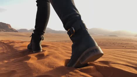 Slow-Motion-shot-of-a-woman-walking-on-top-of-a-sand-dune-in-the-Wadi-Rum-Desert,-Jordan
