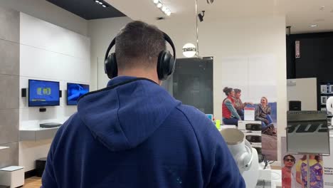 Man-testing-out-noise-canceling-headphones-at-a-Bose-speakers-store