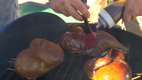 A-man-brushing-BBQ-Sauce-on-to-chicken-during-a-BBQ-Competition
