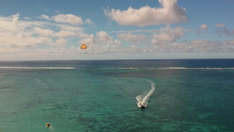 Aerial-shot-of-a-sportboat-pulling-of-a-parachute-to-do-parasail