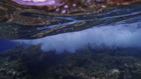 Underwater-shot-of-waves-crushing-on-rocks-in-the-mediterranean-sea